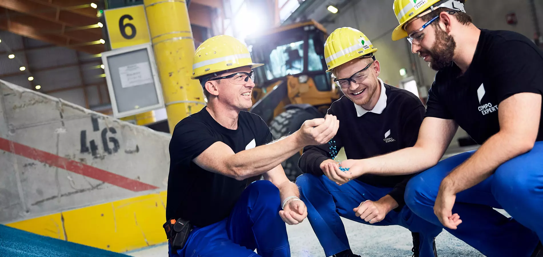 Instructor shows his two trainees the granulate, sitting in a hall